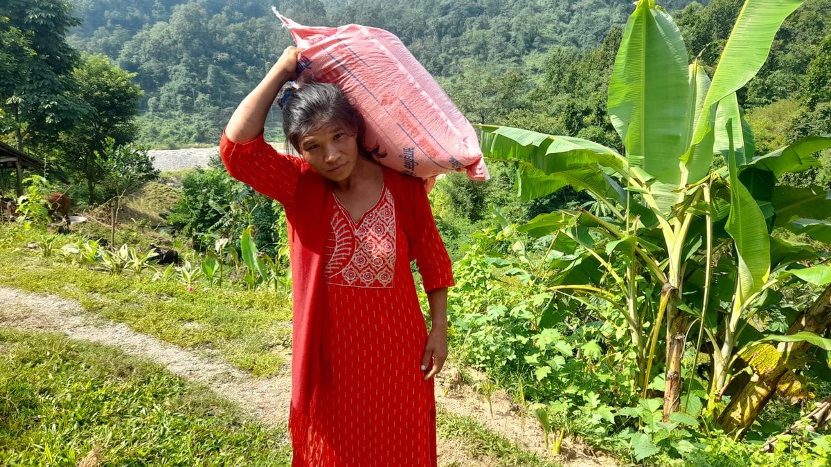 A woman carrying a sack of relief supplies home